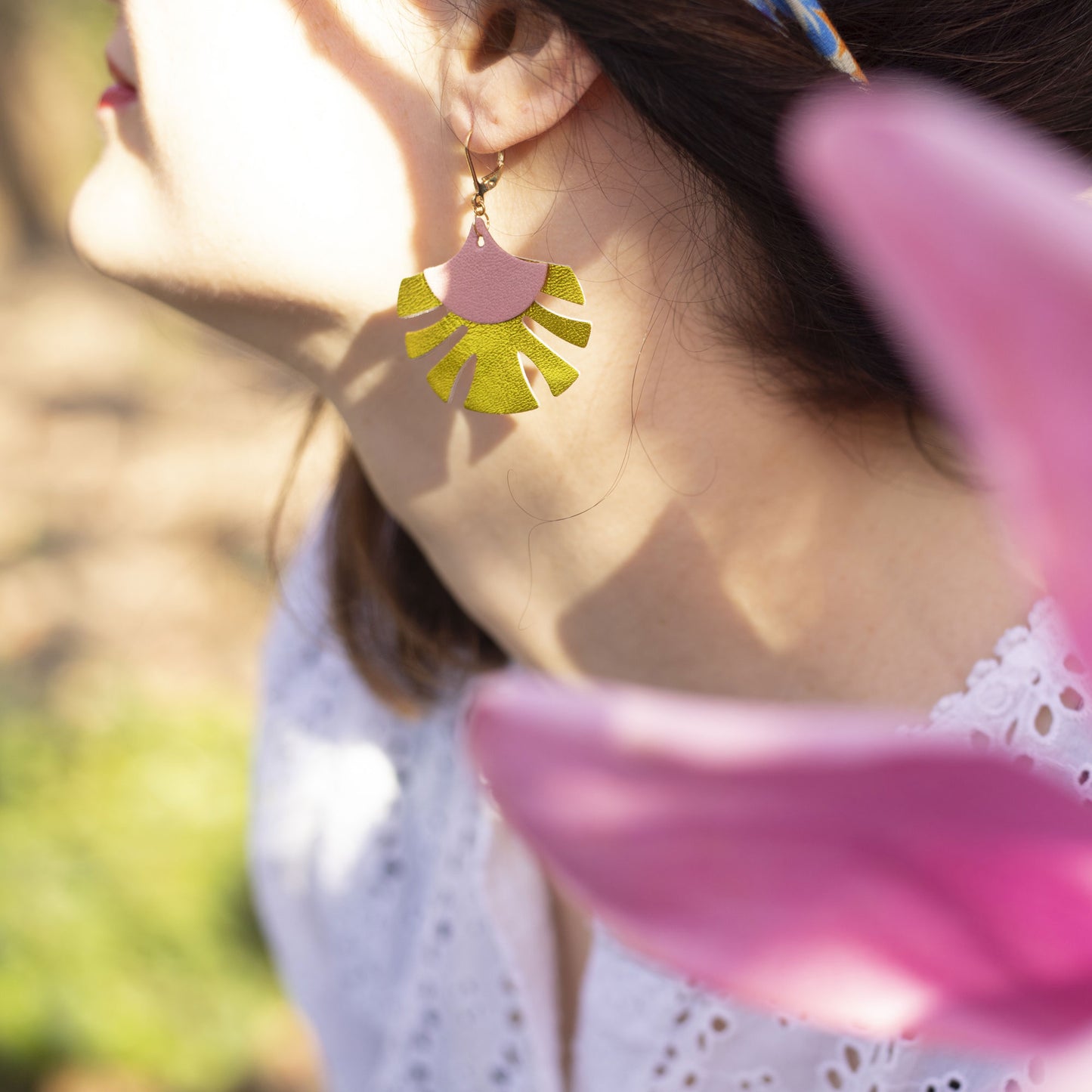 Boucles d'oreilles Chenoha Studio en bijoux cuir dorés et noirs portées sur profil féminin