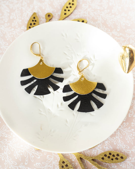 Boucles d'oreilles Chenoha Studio en bijoux cuir dorés et noirs avec design original sur assiette blanche