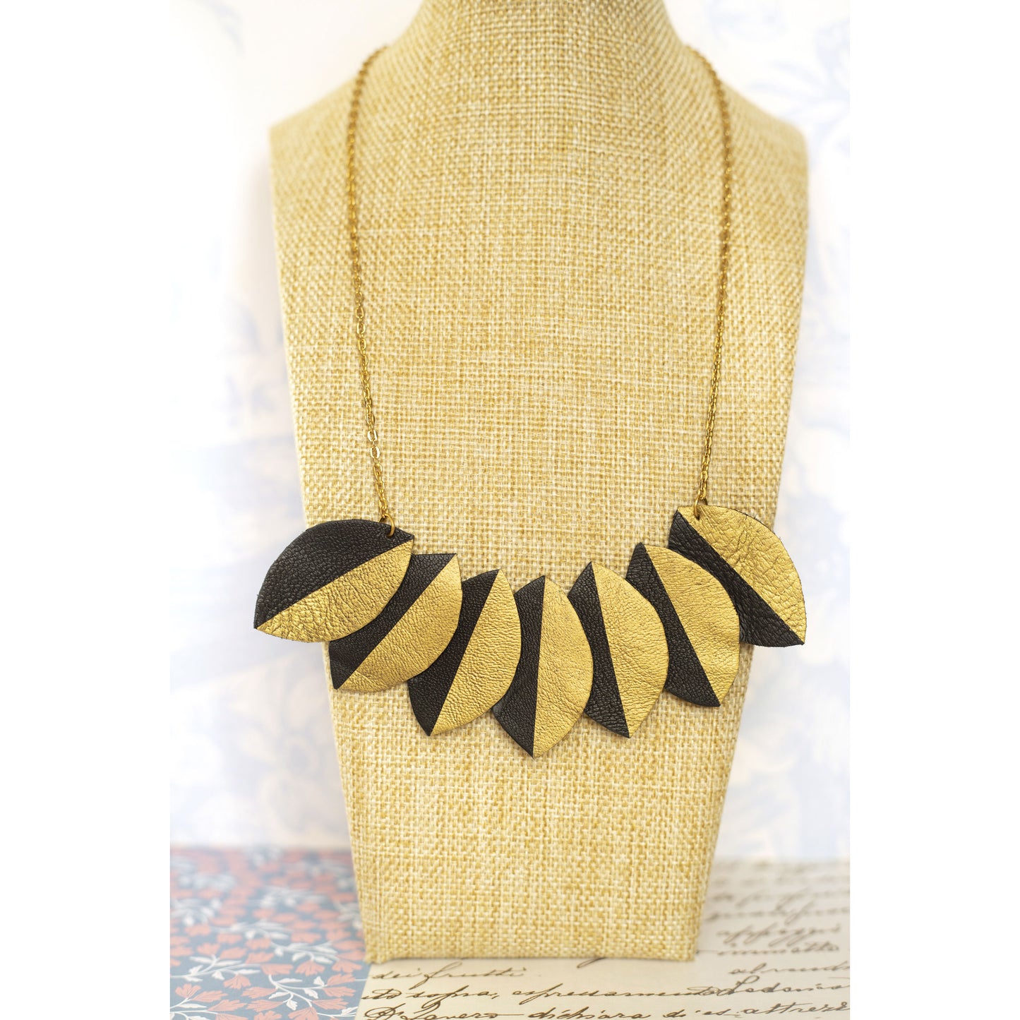 Collier plastron cuir recyclé noir et or design feuille par Chenoha Studio