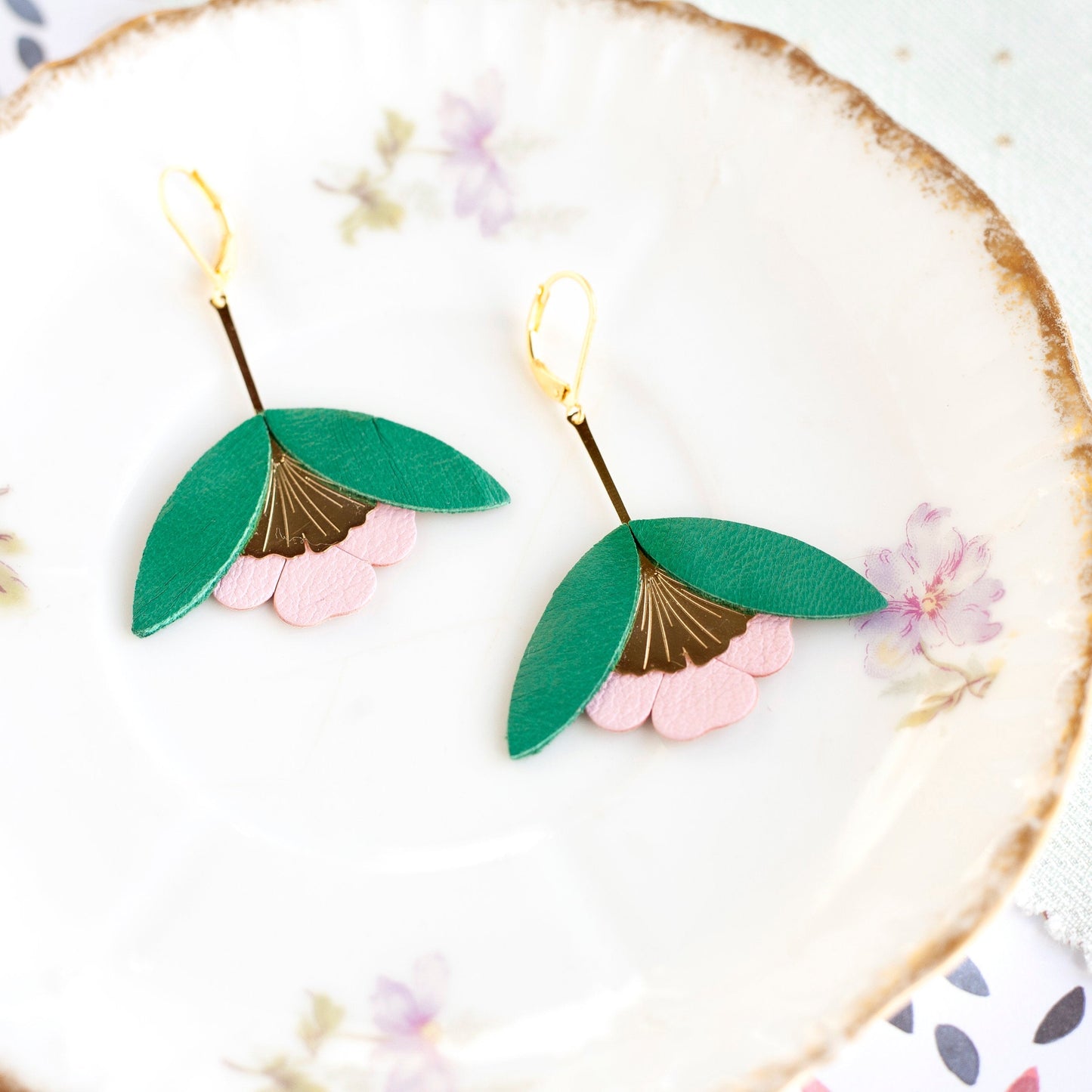 Recycled leather ginkgo flower earrings in green and pink with gold accents.