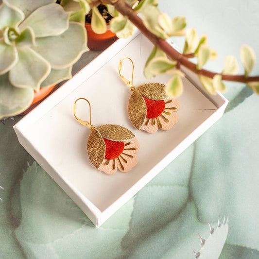 Boucles d'oreilles fleurs de cerisier cuir doré rouge et rose présentées dans une boîte blanche