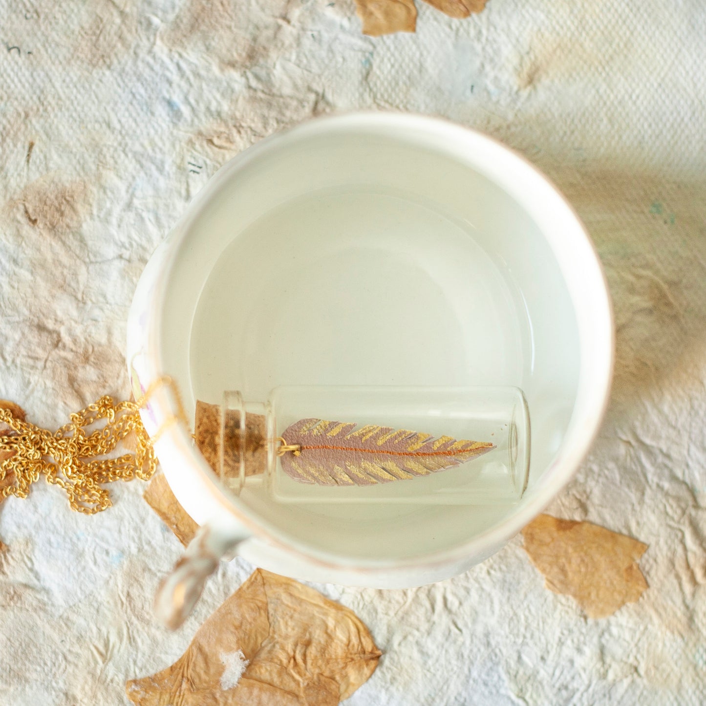 Collier sautoir pendentif fiole en verre avec plume en cuir