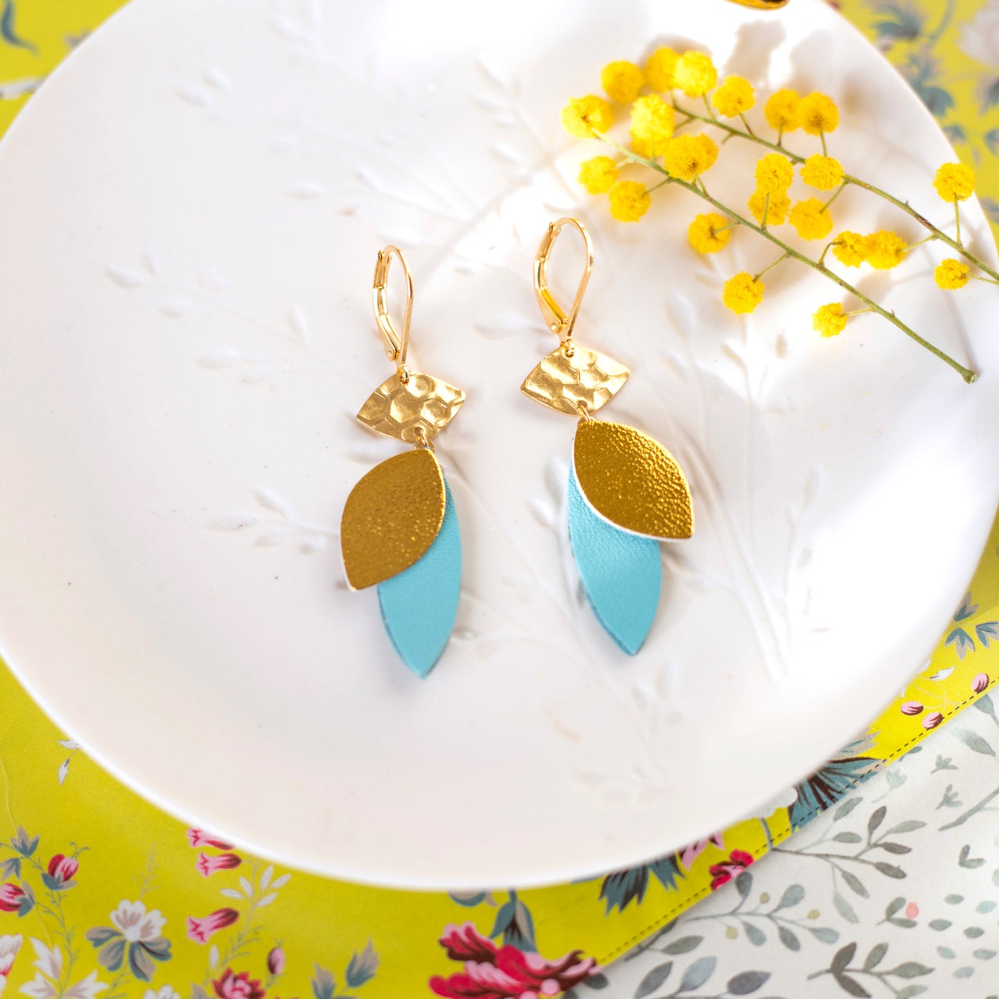 Lozaa-Ohrringe – goldenes Leder und cyanblaue Blütenblätter