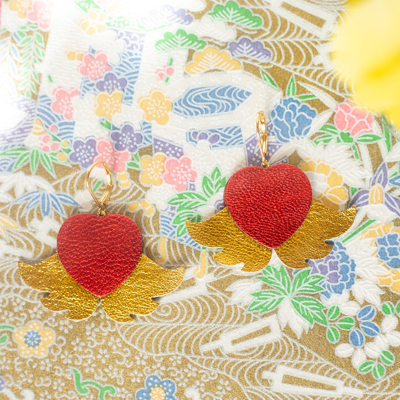 Winged hearts earrings in gold and metallic red leather