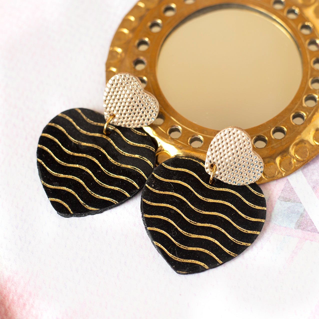 Goldene Doppelherz-Ohrringe mit Punkten und Schwarz