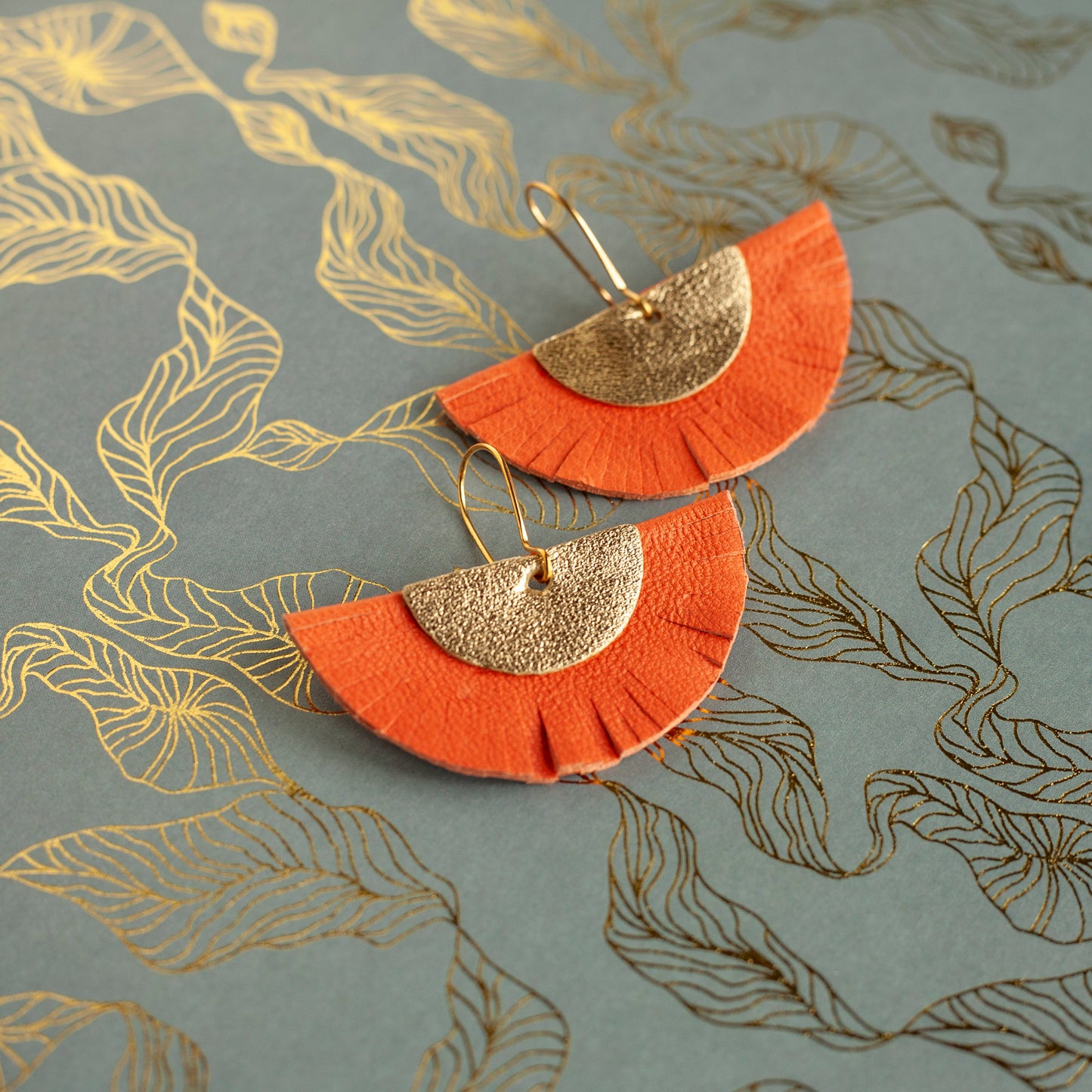 Half-circle fringed earrings in orange and gold leather